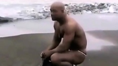 Asian bodybuilder barely covered at the beach